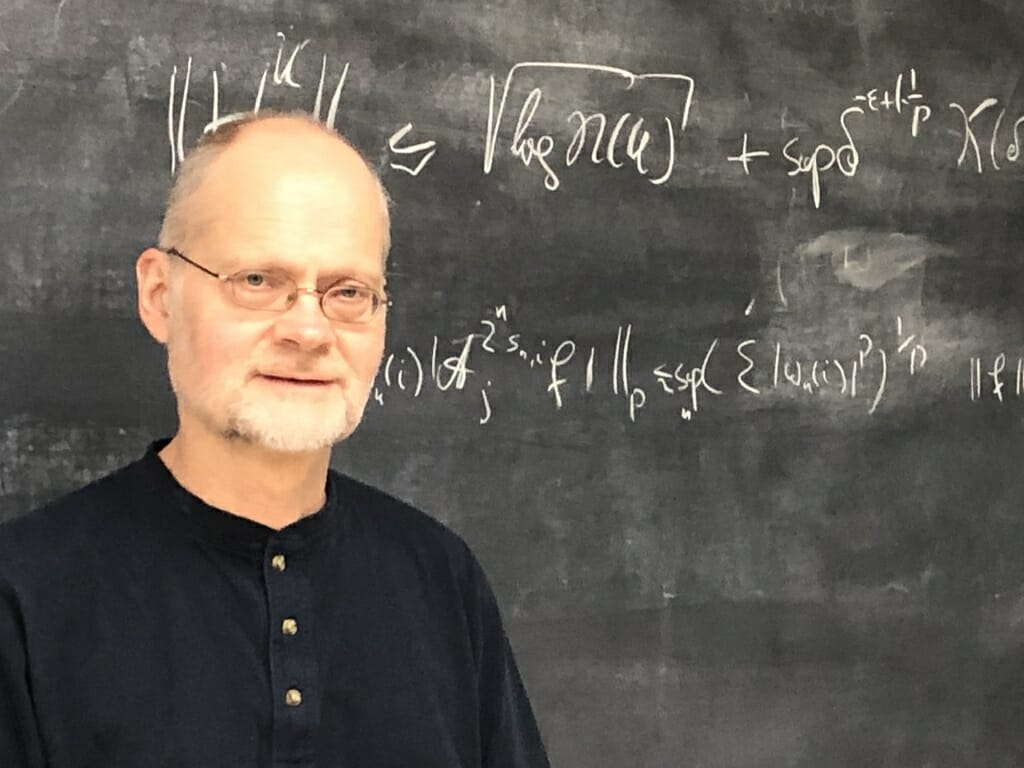 照片:安德烈亚斯格站在黑板前与方程