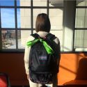 学生带着一个背包和一个绿色的大手帕绑。