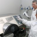 两个工作人员在实验室防护装置的照片站在一个大型离心机。