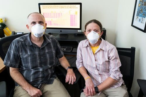 大卫·奥康纳(左)和谢尔比奥康纳坐在电脑屏幕前显示一个电子表格的数据。
