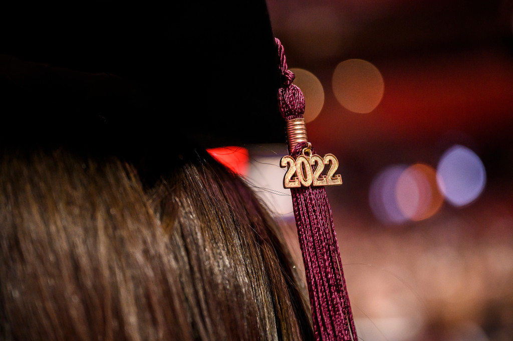 一位毕业生的学位帽上装饰着2022年的花环和流苏。