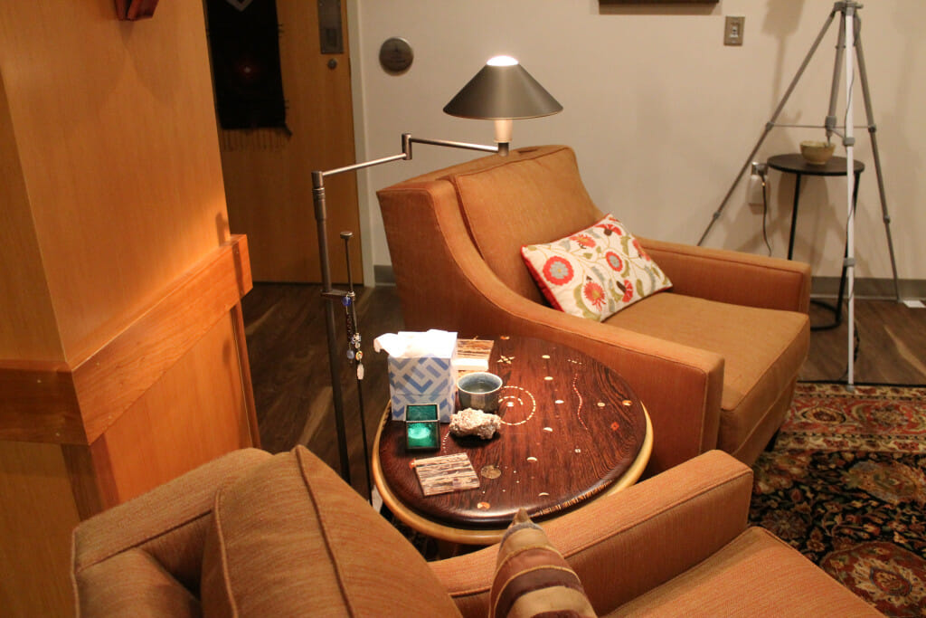 布朗迷幻测试室的另一个视图显示了两个手臂椅子之间有一个圆形的木制茶几。空间装饰得像一客厅。